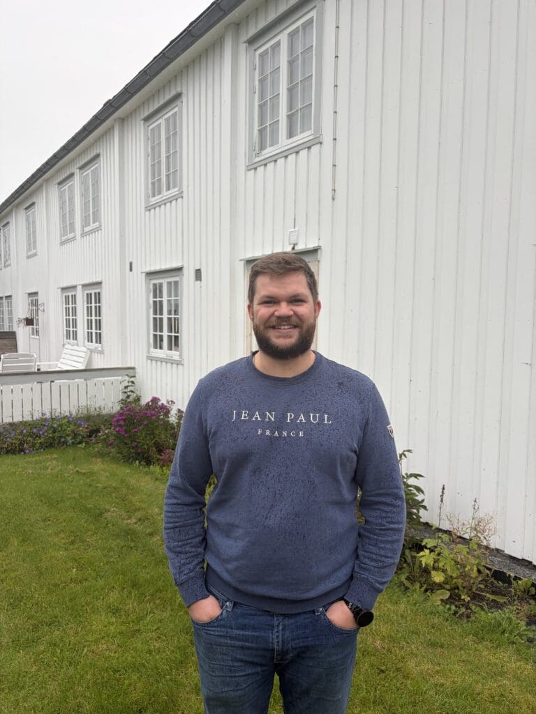 Smilende mann foran ei hvit trønderlån